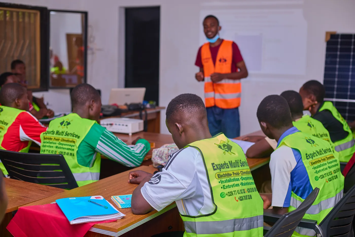 Session de formation Exmuse Burkina : apprenants en gilets Experts Multi Services suivant une présentation technique