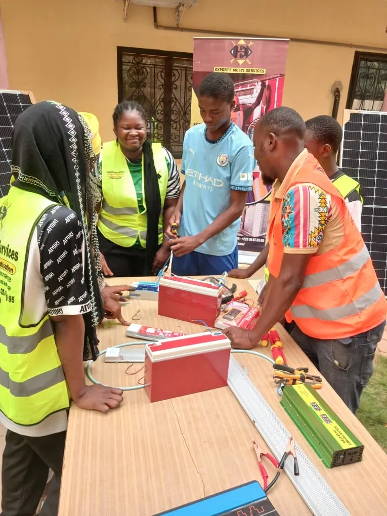 Apprenants en formation pratique sur batteries solaires et onduleurs avec un formateur Exmuse